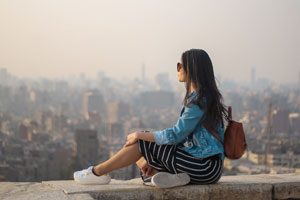 photo d'une femme admirant pensivement un paysage urbain